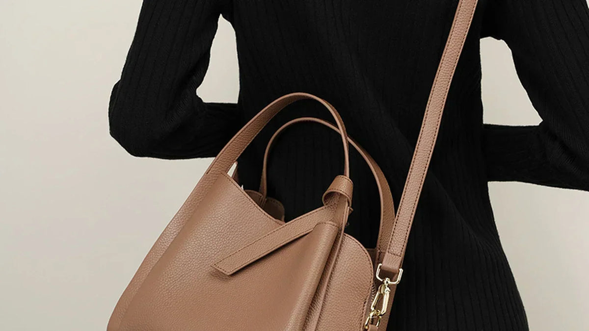 Woman carrying a roomy tan leather shoulder bag that sits sleek against the body, Cuirae blog cover
