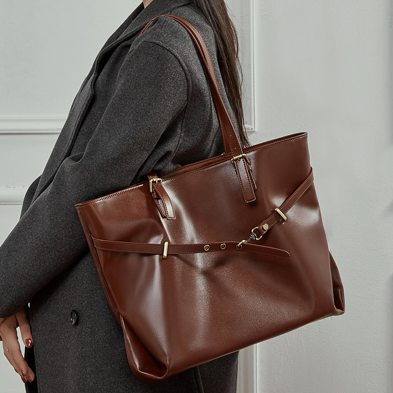 Woman carrying a brown Cuirae leather work tote on her shoulder