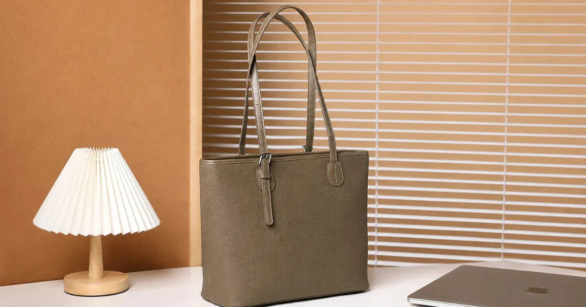 Structured top-grain leather work tote bag standing upright on a modern office desk