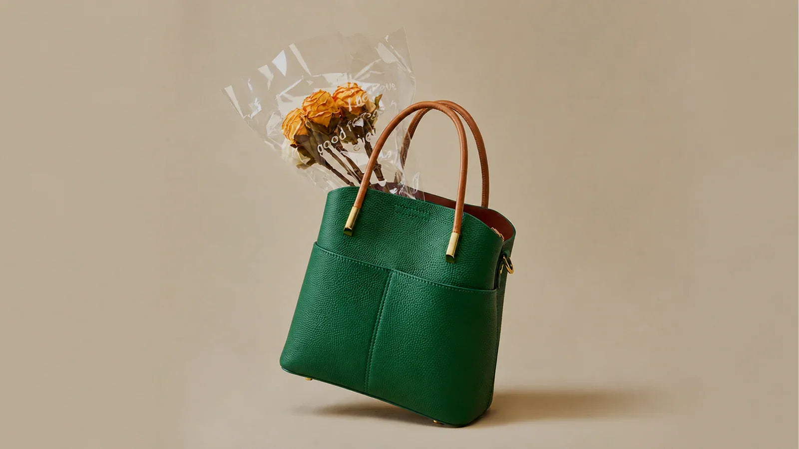 A green leather tote styled with everyday items for a work-bag packing guide