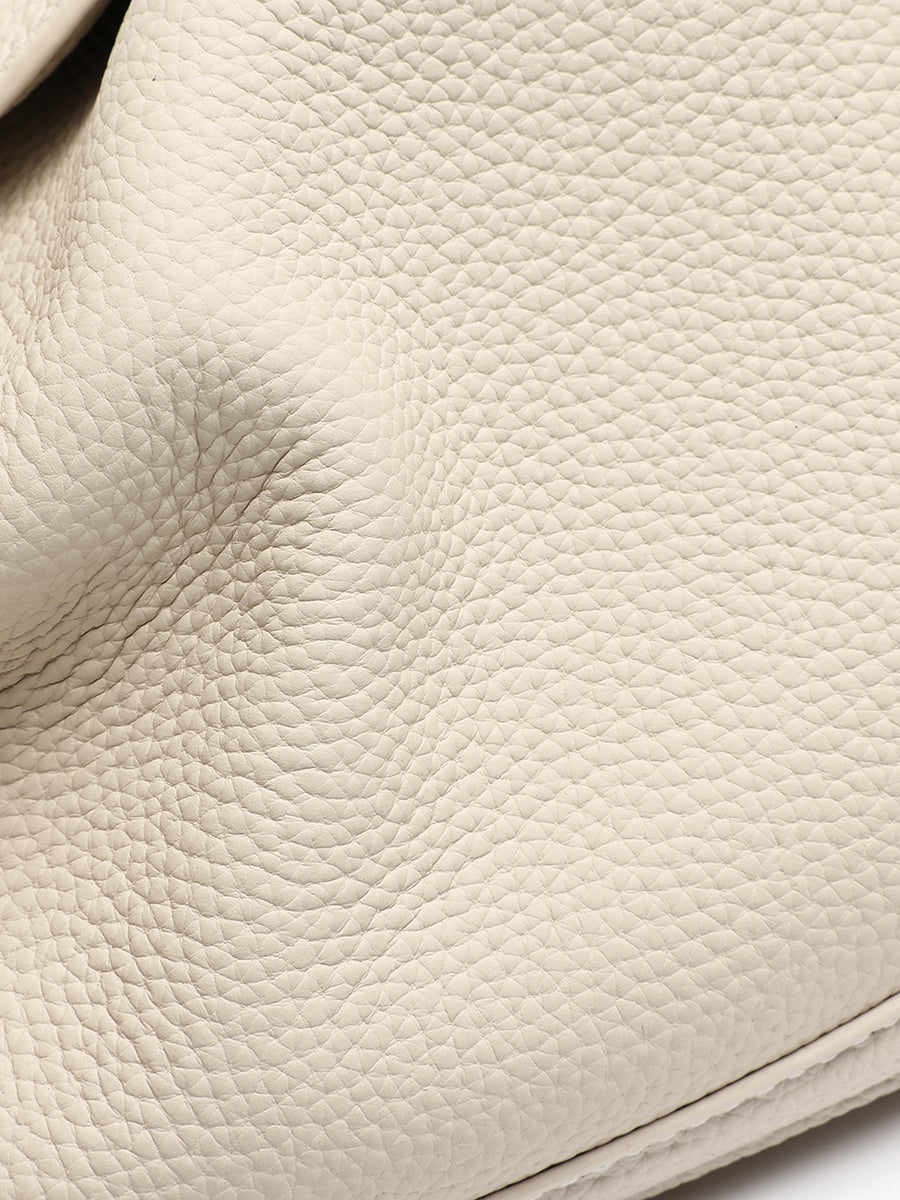 Close-up of the ivory bag's pebbled leather texture