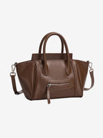 A front view of the Cuirae coffee brown top grain cowhide handbag with a front zipper pocket, sitting on a plain white background.