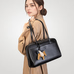 Model wearing Cuirae black genuine leather bowling shoulder bag, side view showing pony charm and zipper closure