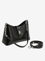 The Cuirae black genuine leather handbag sitting next to an extra long strap on a white background.
