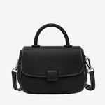 A front view of the Cuirae black genuine leather shoulder bag standing on a plain background