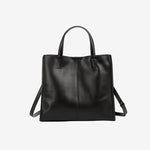 A front view of the Cuirae black genuine leather tote bag standing on a plain background.