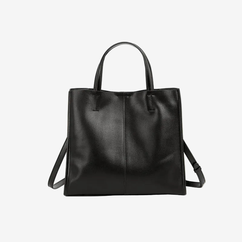 A front view of the Cuirae black genuine leather tote bag standing on a plain background.