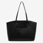 A front view of the Cuirae black genuine leather tote bag standing on a plain background.