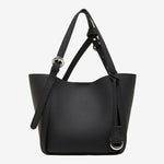 Cuirae black pebbled genuine leather bucket bag with adjustable strap and silver hardware, front view on white background