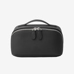 Cuirae black pebbled genuine leather makeup bag with top handle and double zipper, front view on white background.