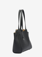 Cuirae black pebbled genuine leather tote bag, angled side view showing tapered side panel and long shoulder straps