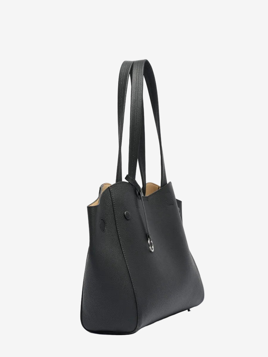 Cuirae black pebbled genuine leather tote bag, angled side view showing tapered side panel and long shoulder straps