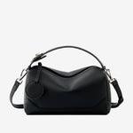 Cuirae black pebbled genuine leather bowling handbag with round charm and silver hardware, front view on white background