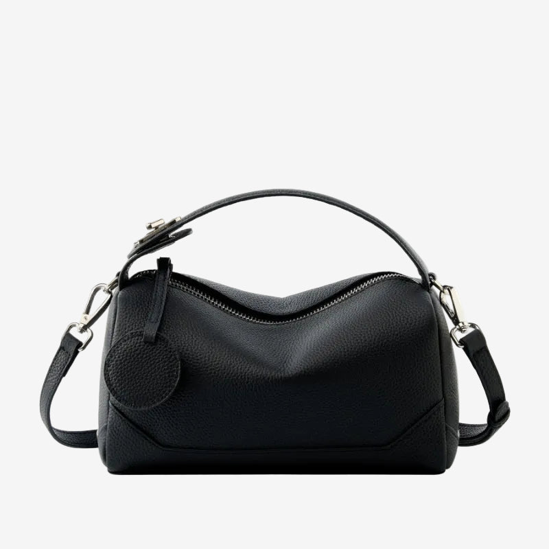Cuirae black pebbled genuine leather bowling handbag with round charm and silver hardware, front view on white background