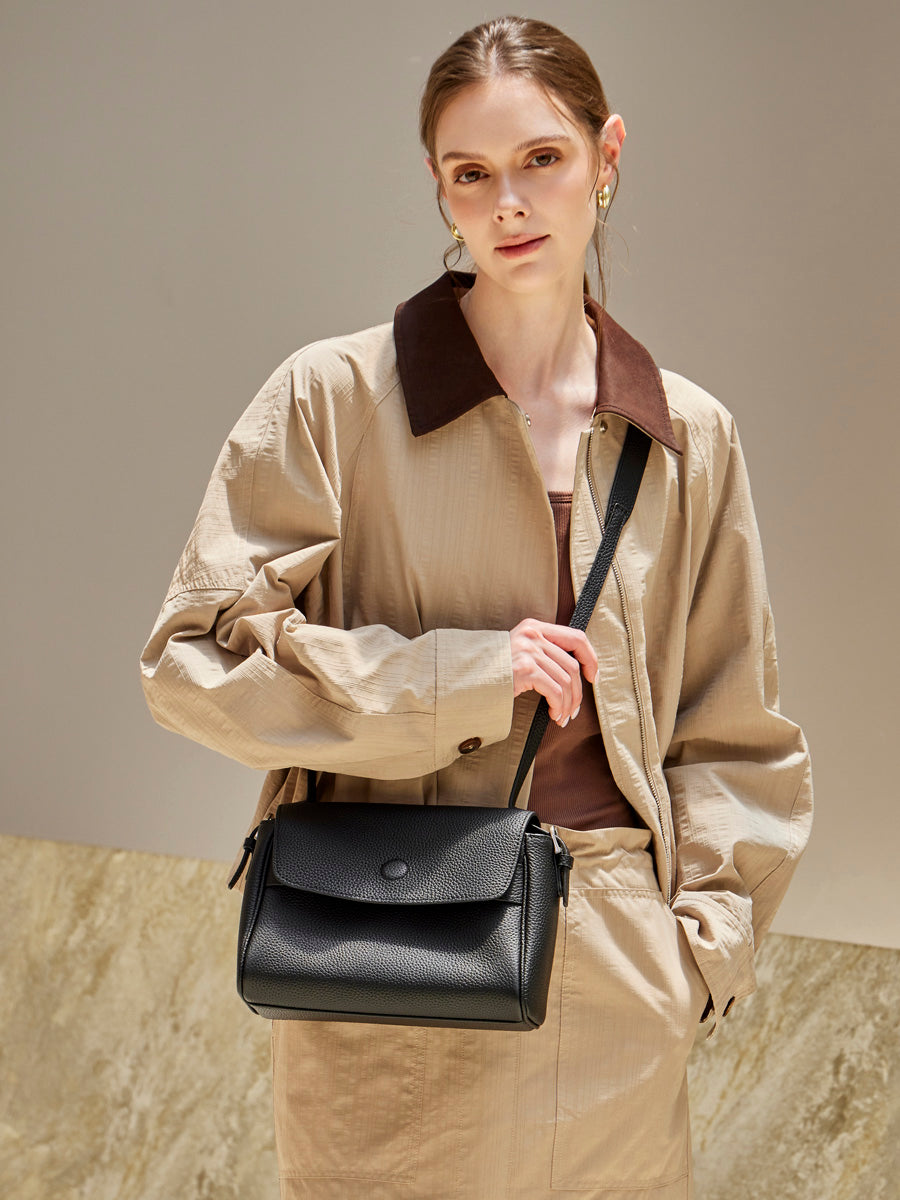 Model wearing the Cuirae black pebbled leather flap crossbody bag, front view