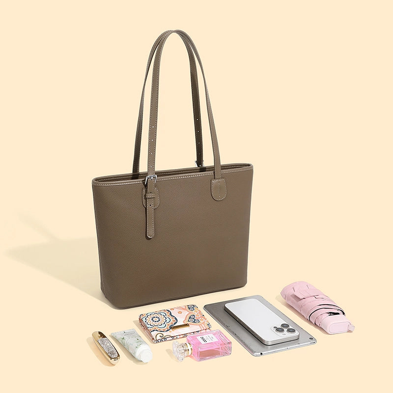 The Cuirae brown genuine leather tote bag with various items 