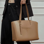 A model holding the Cuirae brown genuine leather bag in her hand.