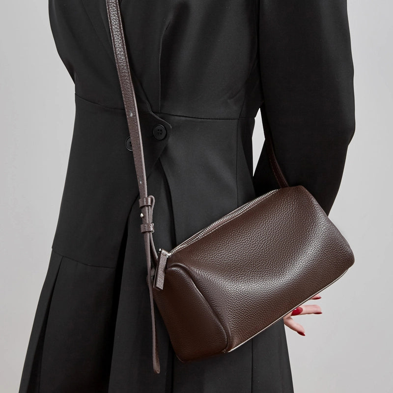 Cuirae brown genuine leather barrel crossbody bag worn crossbody by model, angled view showcasing smooth finish
