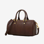 Cuirae brown genuine leather barrel crossbody bag with gold hardware and detachable strap, side view on white background