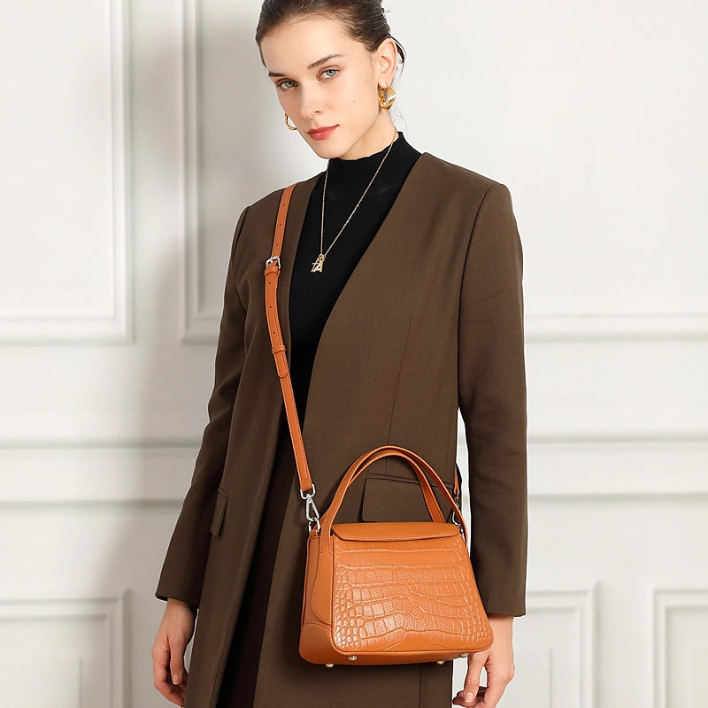 Cuirae brown genuine leather crossbody bag worn crossbody by model, showing adjustable strap and classic design