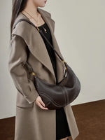 Woman wearing Cuirae  brown genuine  leather hobo bag crossbody style, front view showing an adjustable shoulder strap