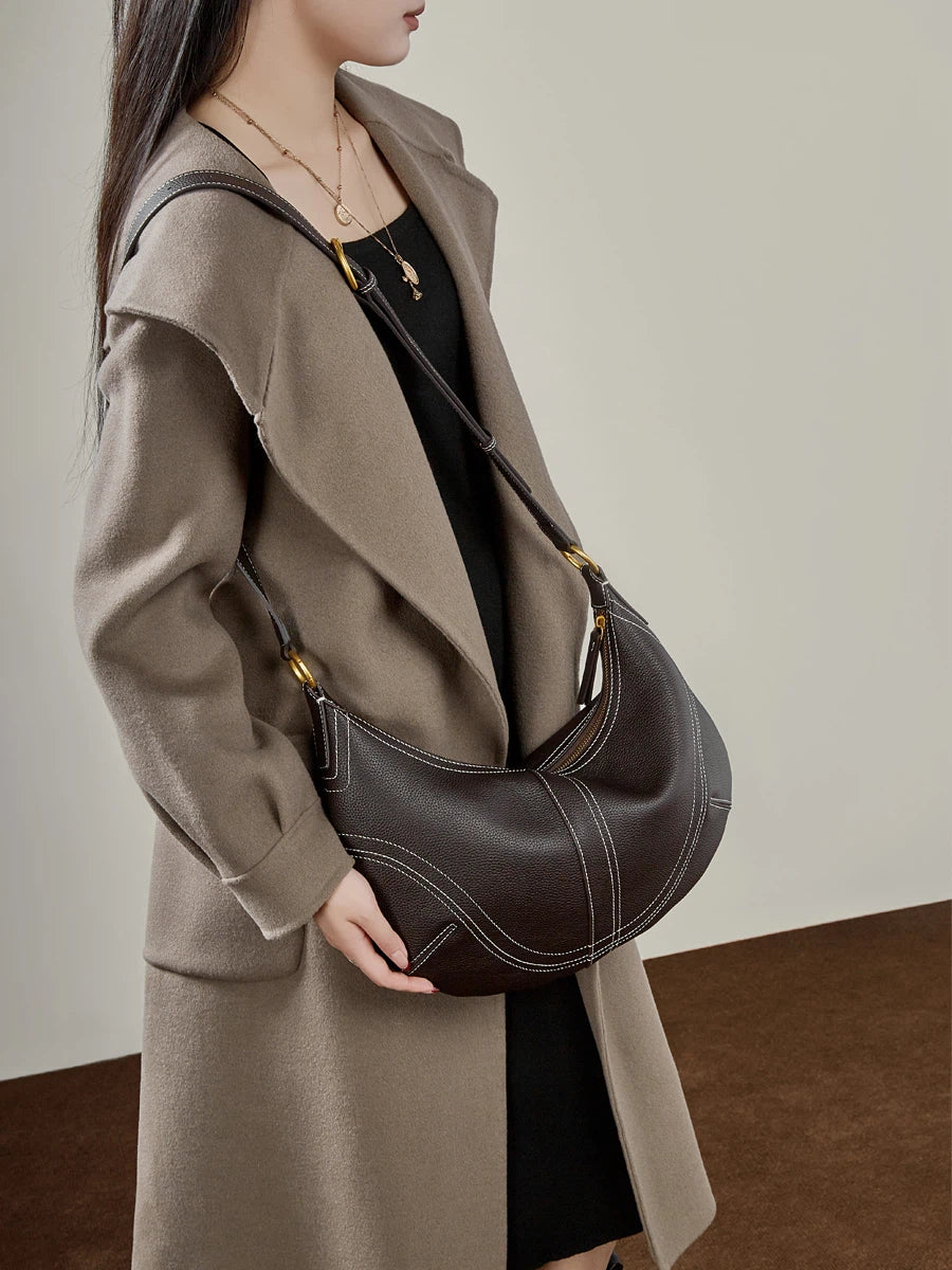 Woman wearing Cuirae  brown genuine  leather hobo bag crossbody style, front view showing an adjustable shoulder strap
