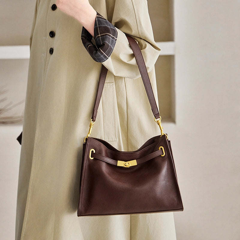 Cuirae brown genuine leather hobo crossbody bag worn on the shoulder by the model, front view with gold turnlock hardware