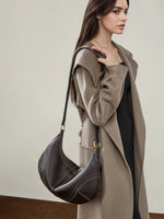 Model wearing Cuirae  brown genuine leather hobo shoulder bag, side view showing gold hardware and slouchy silhouette