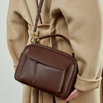 Cuirae brown genuine leather mini shoulder bag worn on shoulder, back view showing soft leather texture