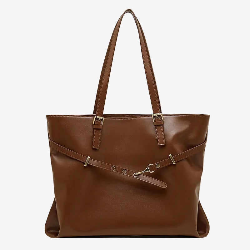 A front view of the Cuirae brown genuine leather tote bag standing on a plain background. 
