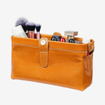 Cuirae brown glossy genuine leather makeup bag open with cosmetics inside, showing spacious interior on white background