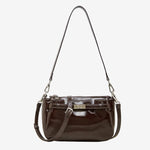 Cuirae brown glossy genuine leather crossbody bag with turnlock detail and adjustable strap, front view on white background