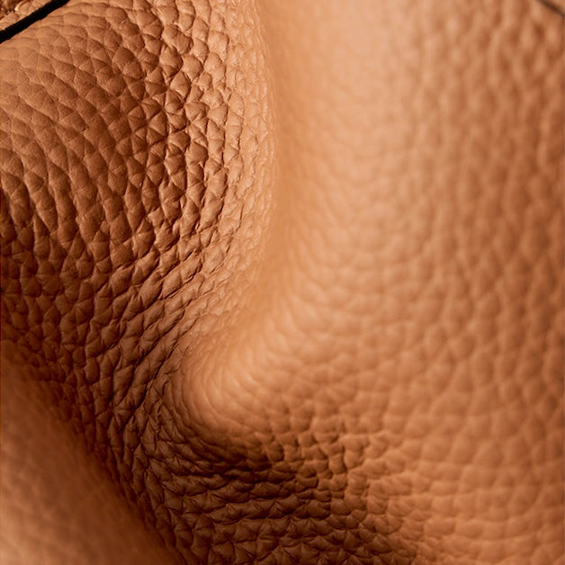 Close-up of the brown bucket bag’s pebbled top-grain cowhide texture