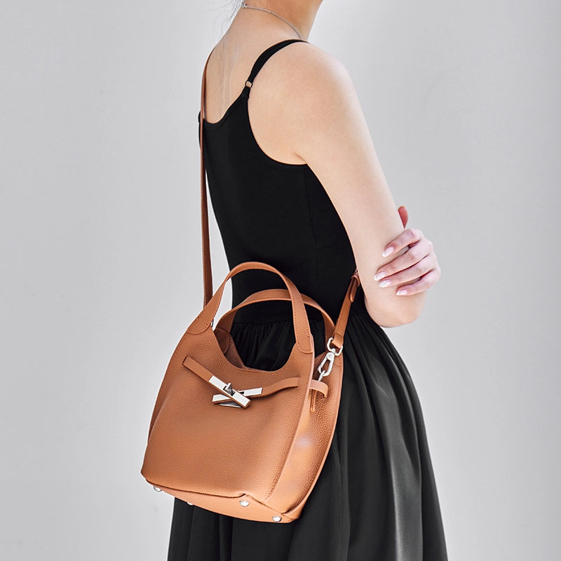 Model wearing Cuirae brown leather hobo crossbody bag crossbody, back view showing detachable strap and bottom studs