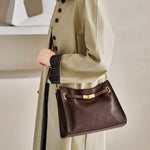 Woman wearing Cuirae  brown leather hobo crossbody bag, side view showcasing gold hardware details and soft texture