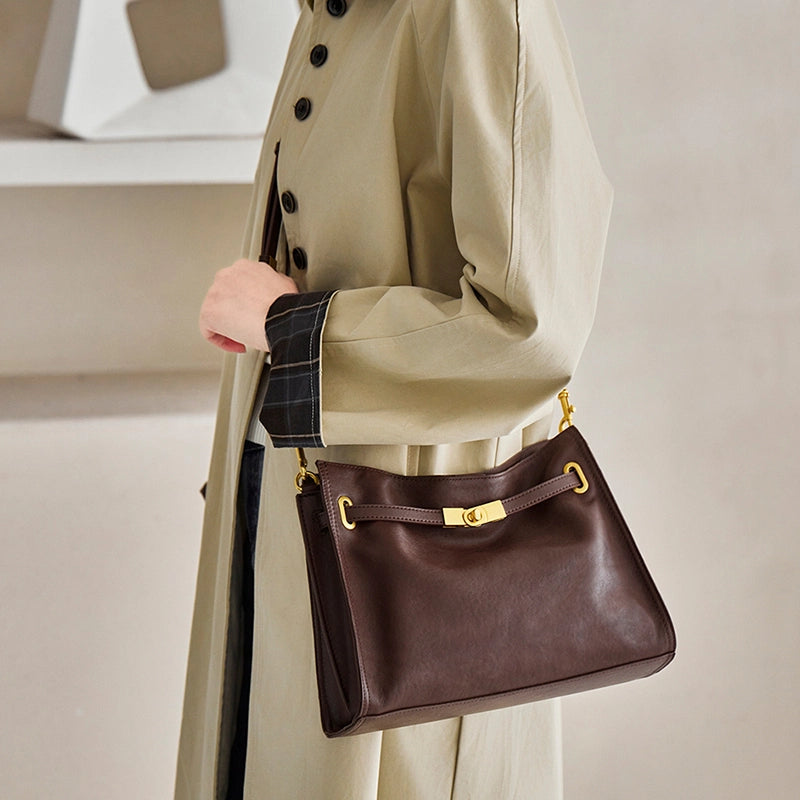 Woman wearing Cuirae  brown leather hobo crossbody bag, side view showcasing gold hardware details and soft texture