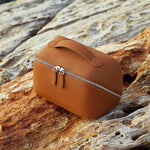 Cuirae brown pebbled genuine leather makeup bag with double zipper and top handle, outdoor still life on rock in natural light
