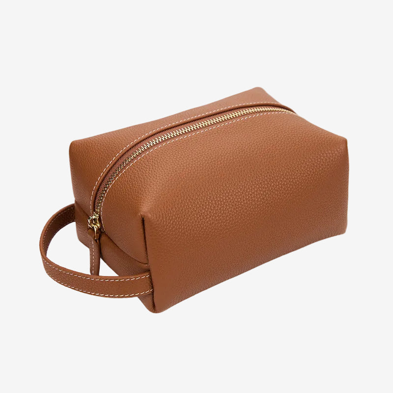 Cuirae brown pebbled genuine leather makeup bag with gold zipper and wrist strap, front angled view on white background