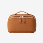 Cuirae brown pebbled genuine leather makeup bag with top handle and double zipper, front view on white background.