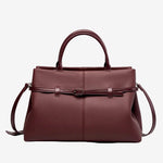 Cuirae burgundy pebbled genuine leather handbag with belt buckle detail and silver hardware, front view on white background