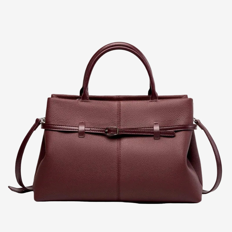 Cuirae burgundy pebbled genuine leather handbag with belt buckle detail and silver hardware, front view on white background