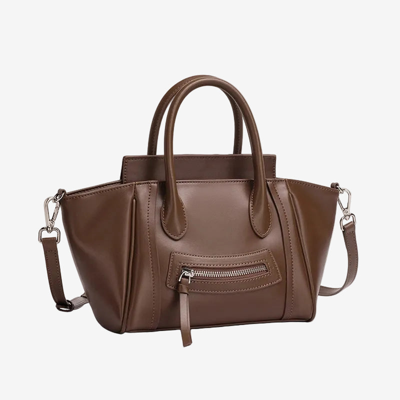 A front view of the Cuirae coffee brown top grain cowhide handbag with a front zipper pocket, sitting on a plain white background.