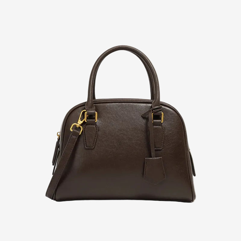 Cuirae  coffee genuine leather dome handbag with detachable shoulder strap and tag charm, front view on white background
