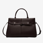 Cuirae coffee pebbled genuine leather handbag with belt buckle detail and silver hardware, front view on white background