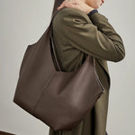 A model carrying the Cuirae coffe genuine leather tote bag under her arm.