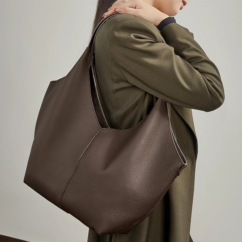 A model carrying the Cuirae coffe genuine leather tote bag under her arm.
