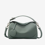 Cuirae dusty green pebbled genuine leather bowling handbag with round charm and silver hardware, front view on white background
