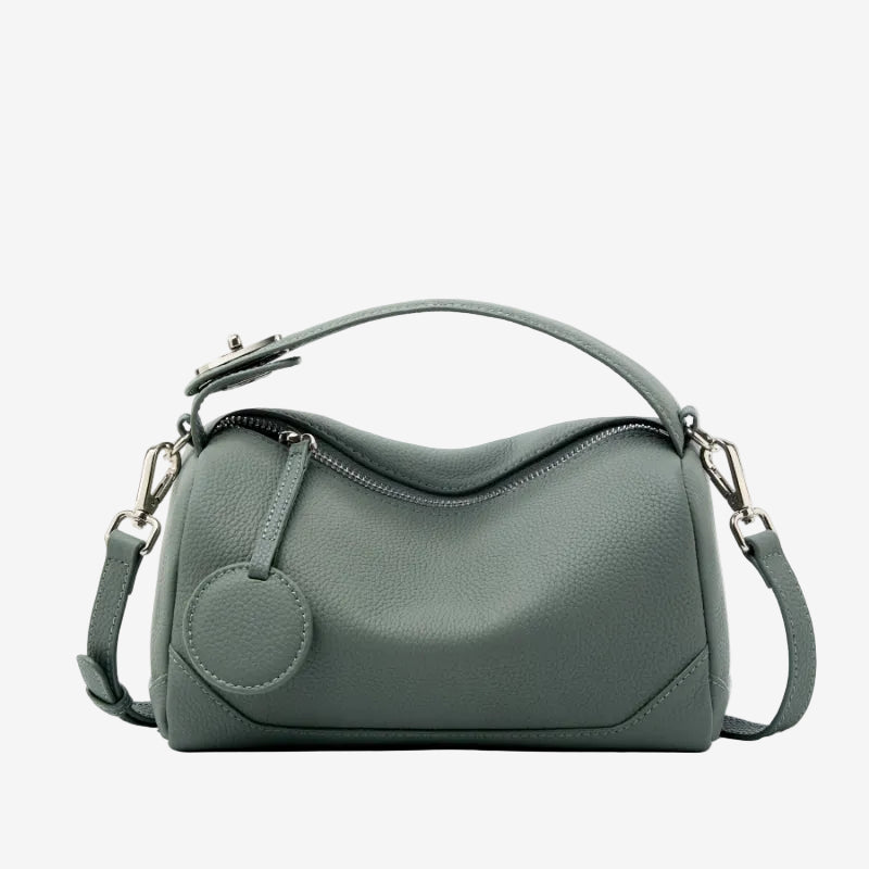 Cuirae dusty green pebbled genuine leather bowling handbag with round charm and silver hardware, front view on white background