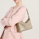 Woman wearing a Cuirae gray genuine leather shoulder bag under the arm, side view, everyday wear style