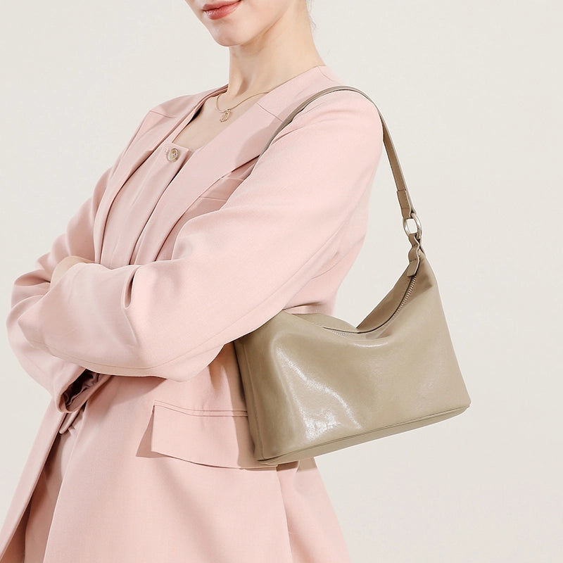 Woman wearing a Cuirae gray genuine leather shoulder bag under the arm, side view, everyday wear style